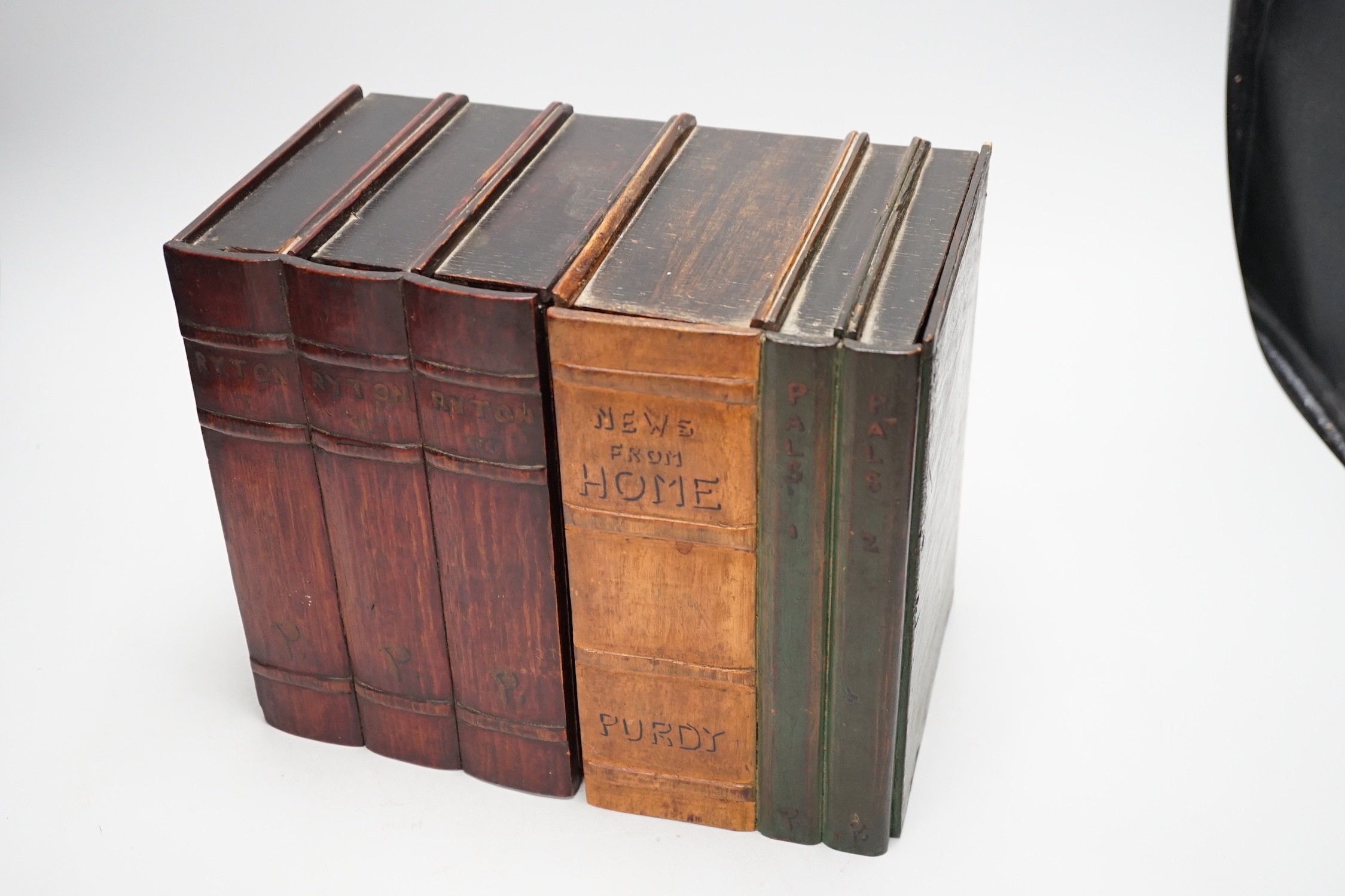 An early 20th century painted carved oak novelty stationary box modelled as books, 27cm wide, 23cm tall, 16cm deep